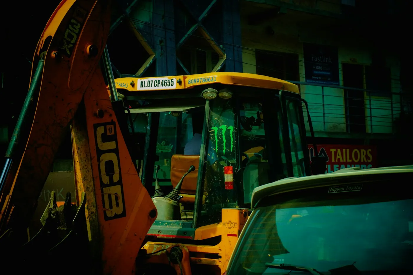 Backhoe loader beside a building at dusk