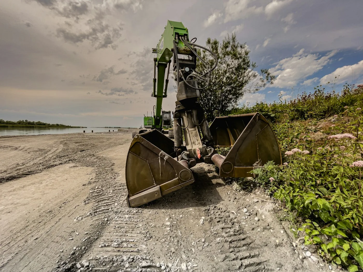 Excavator and bucket on a broad gravel surface