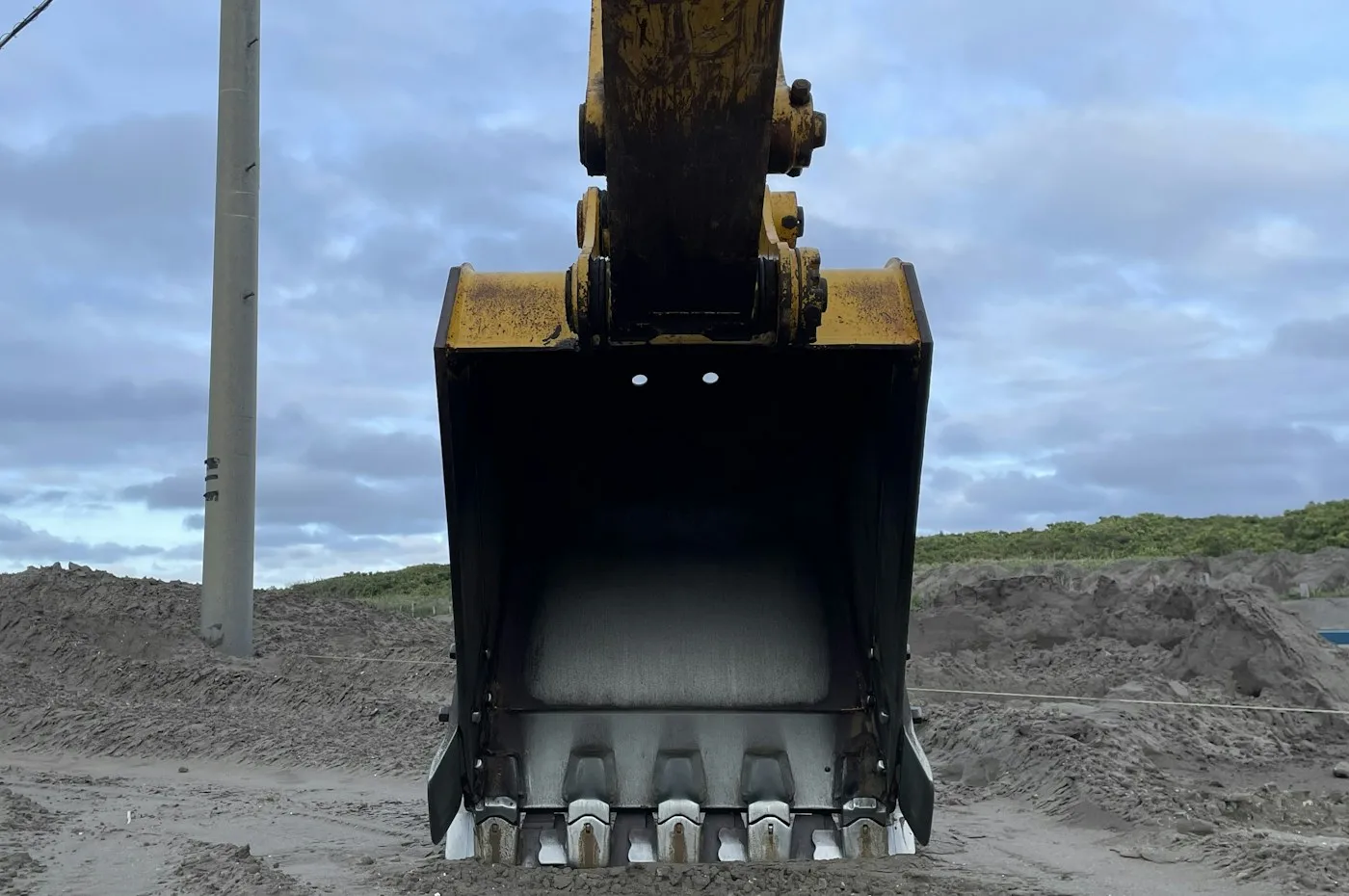 Excavator bucket close to gravel ground